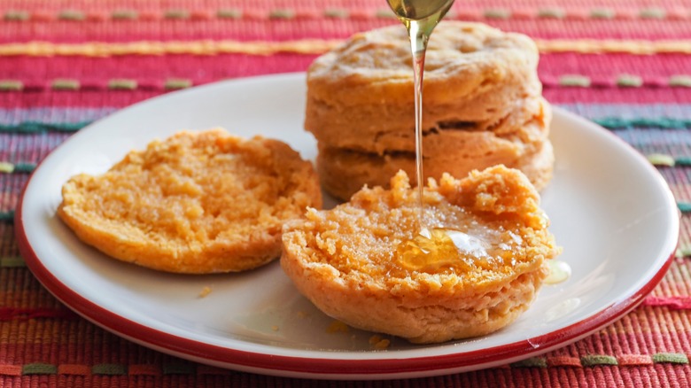 Biscuits being drizzled with honey