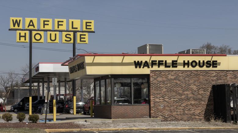 Exterior of Waffle House building, cars parked in front