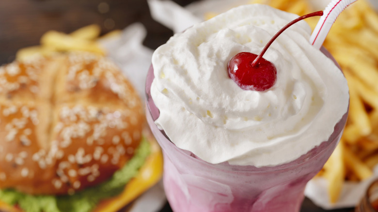 burger, fries and berry milkshake with whipped cream