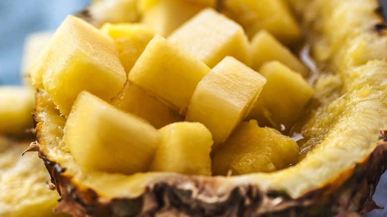 Closeup of cut pineapple chunks in a halved pineapple