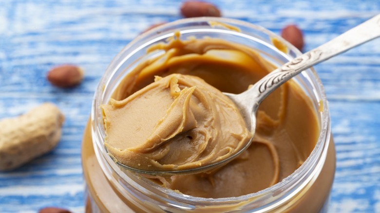 a spoon in a jar of peanut butter
