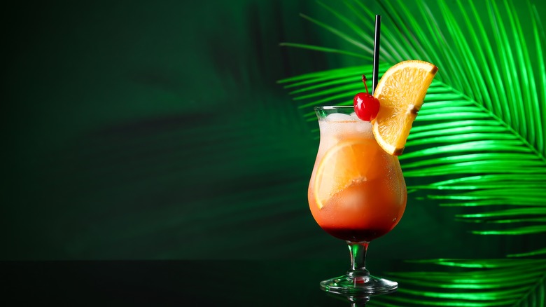tequila sunrise with palm leaf background