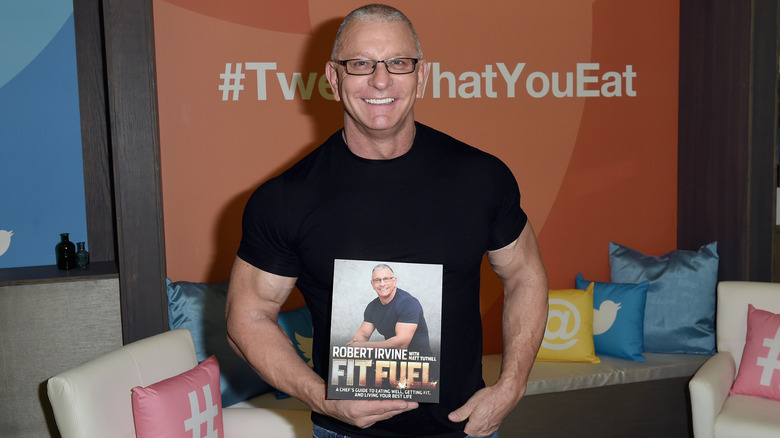 Chef Robert Irvine holding a copy of his book Fit Fuel