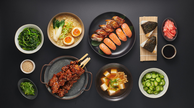 a selection of diverse Japanese dishes on a black table