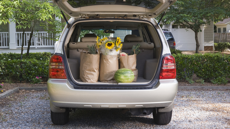Loading groceries into the trunk of a car
