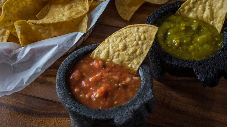 bowls of green and red salsa with chips at Mexican restaurant