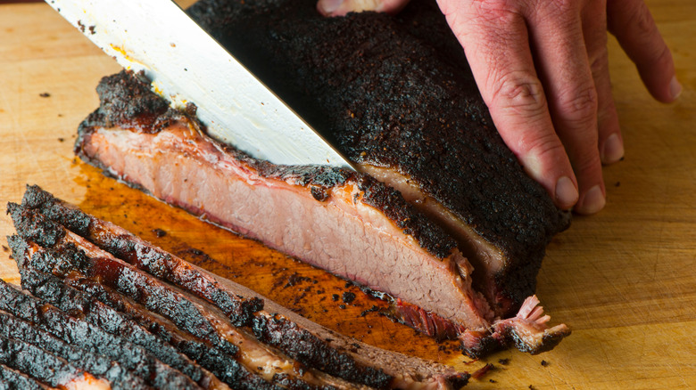 slicing barbecue brisket with bark