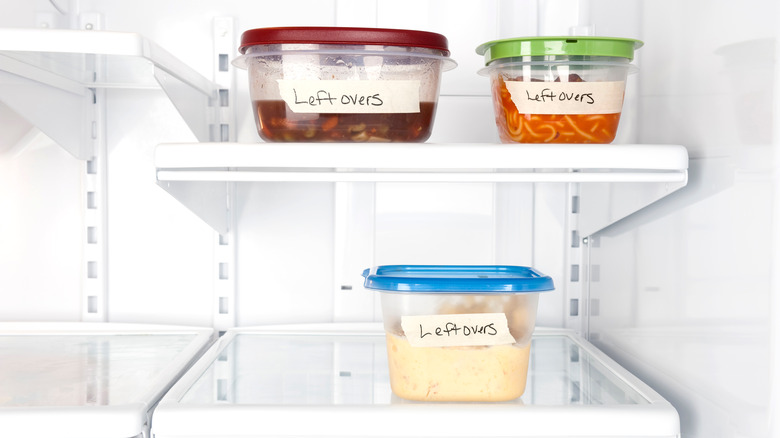 three containers of leftovers on refrigerator shelves