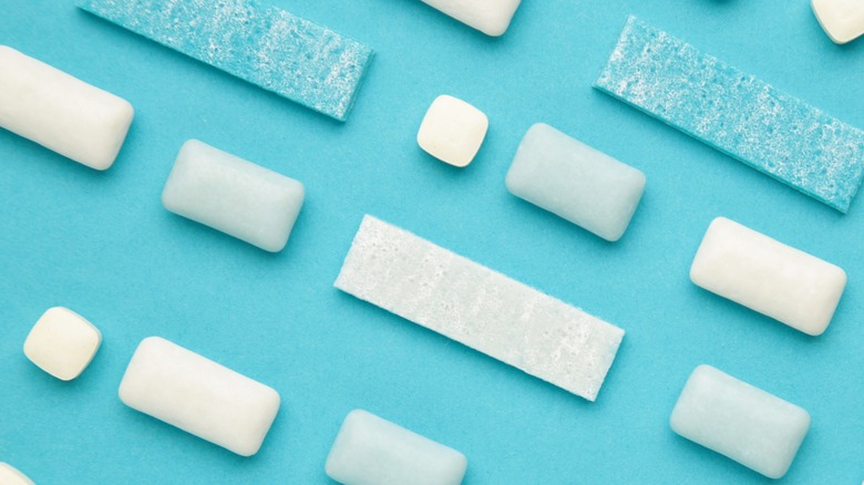 Different pieces of chewing gum on blue background