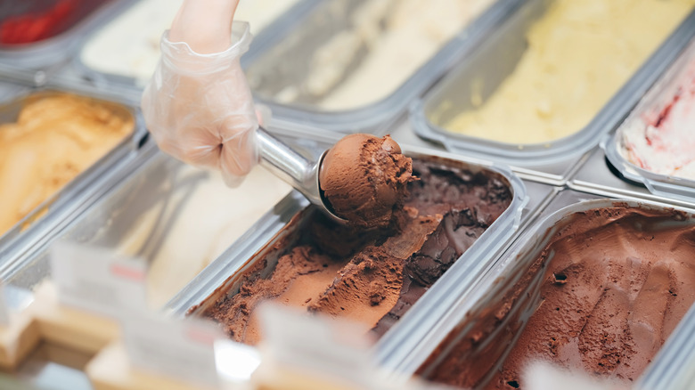 Someone scooping up some ice cream at an ice cream shop