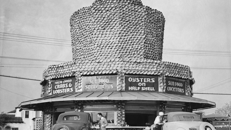 A historical photo of a roadside seafood stand decorated with thousands of abalone shells