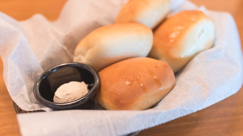 Basket of Texas Roadhouse rolls with side of cinnamon butter