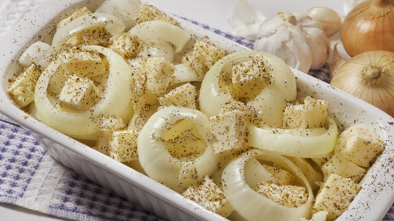 raw Tennessee onion casserole in dish with seasonings sprinkled over