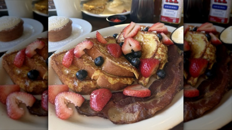 A plate of French toast with berries and cream