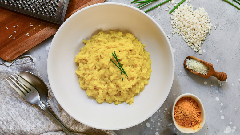 risotto milanese in bowl surrounded by ingredients