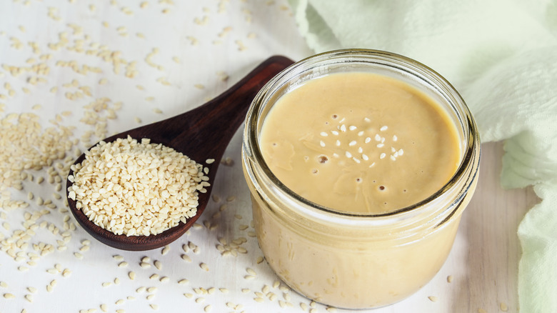tahini with a spoon full of sesame seeds