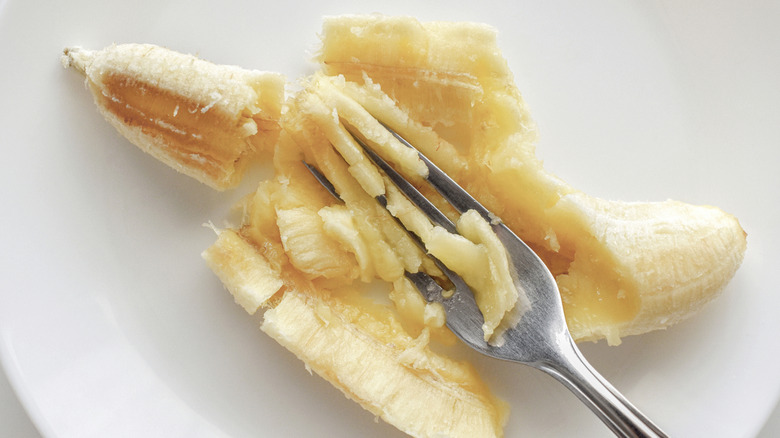 Mashed bananas on a plate with a fork