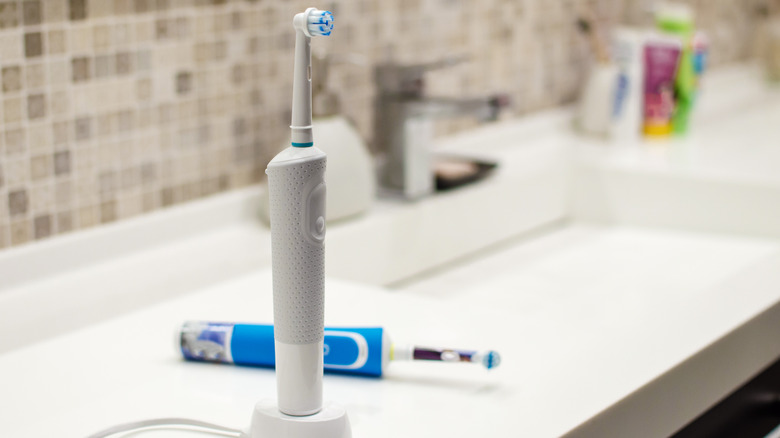 rechargeable electric toothbrush sitting on bathroom sink