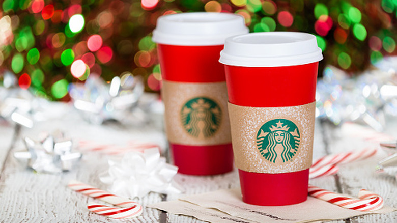 starbucks holiday drinks in front of a christmas tree