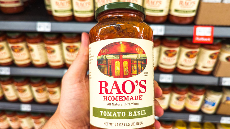 Man holding a jar of Rao's Homemade tomato basil sauce