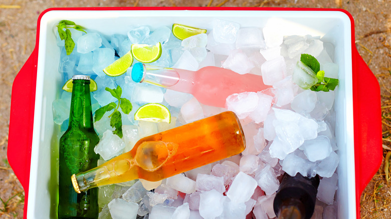a top-down view of a red plastic cooler filled with brightly colored drinks and ice