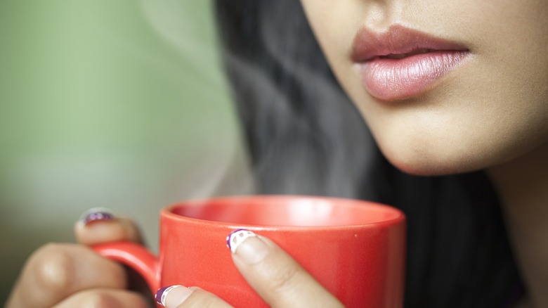 Close-up of woman holding a steaming mug