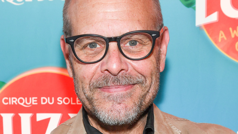 Alton Brown smiles in close-up with glasses