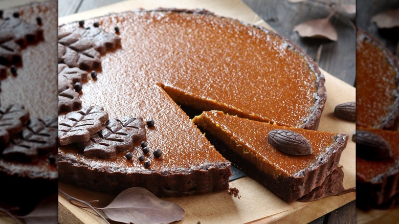 Close-up of pumpkin pie with chocolate crust on a table