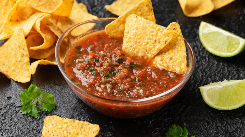 Salsa with chips and lime wedges