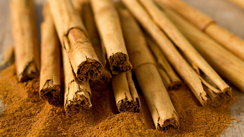 a pile of Ceylon cinnamon sticks resting on a mound of ground cinnamon