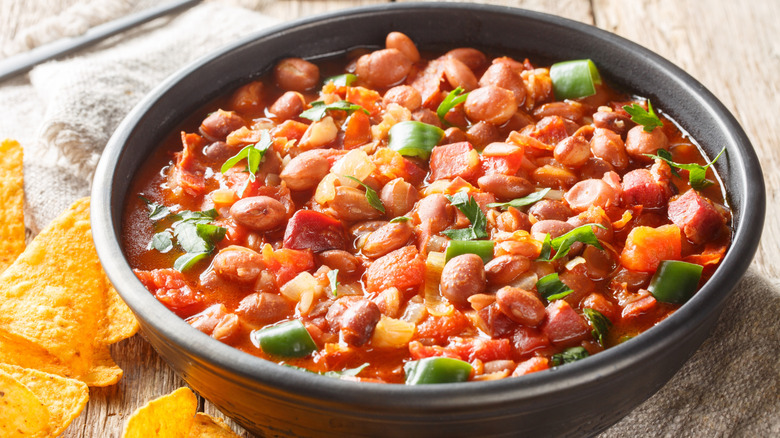 close up of a bowl of frijoles charros and tortilla chips