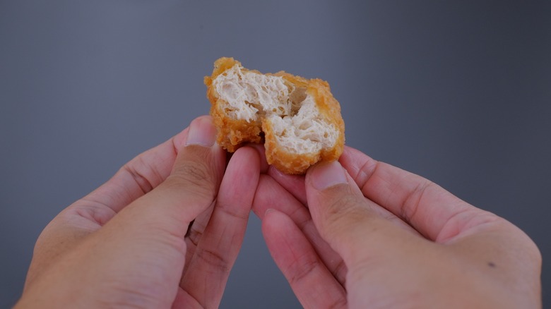 hands tearing fried tofu