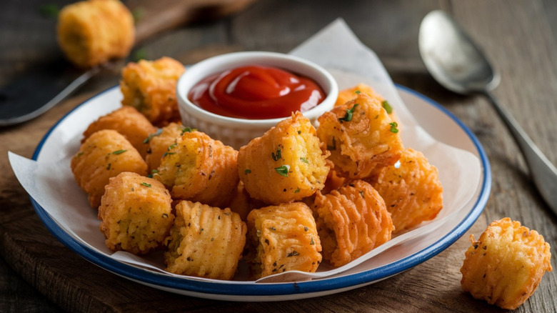Plate of tater tots with ketchup on a dish