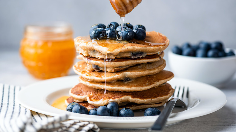 Golden pancakes with berries, honey