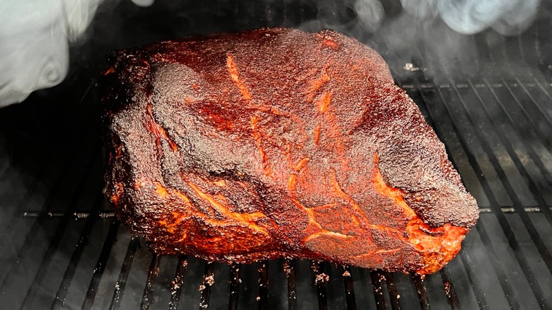 A BBQ smoked pork shoulder on a grill