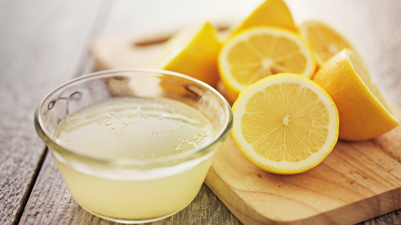 Bowl of lemon juice and halved lemons