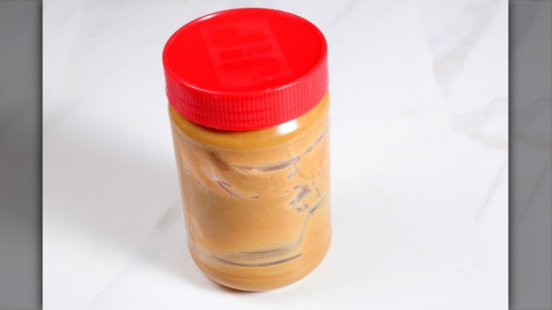 empty jar of peanut butter with red lid