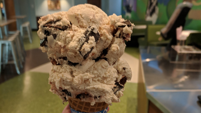 Two scoops of chunky Ben & Jerry's ice cream sit on a cone.