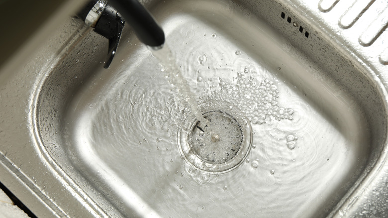 Water flowing into blocked steel kitchen sink