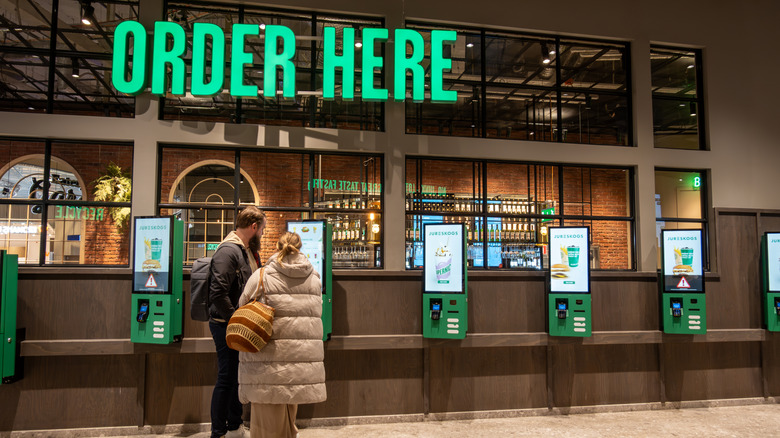 couple ordering from fast food kiosk