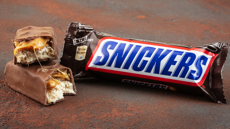 Snickers bar in packet and halved Snickers bar beside