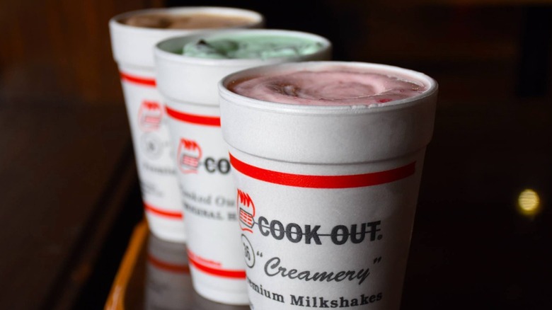three Cook Out milkshakes on black background