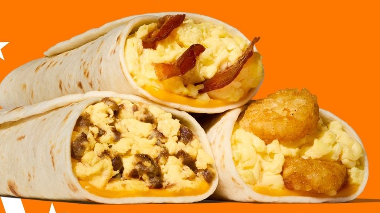 Three Whataburger taquitos stacked on top of each other with bacon, sausage, and potato and egg fillings