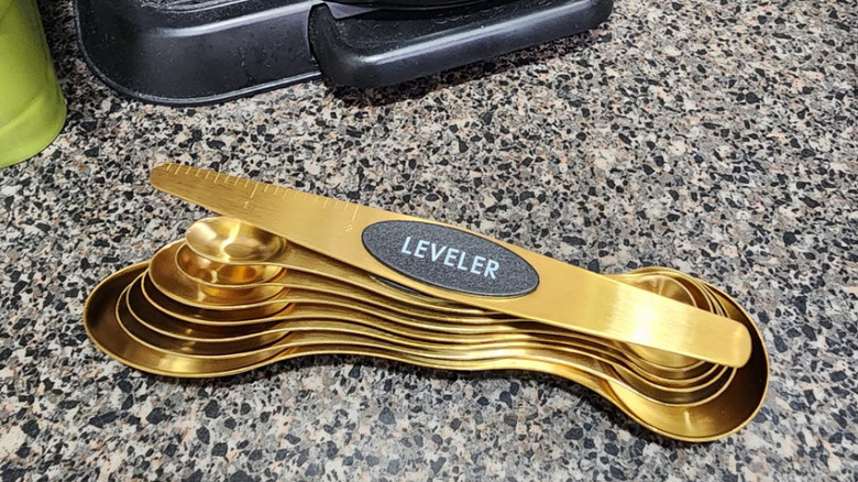 A set of magnetic measuring spoons on a kitchen counter