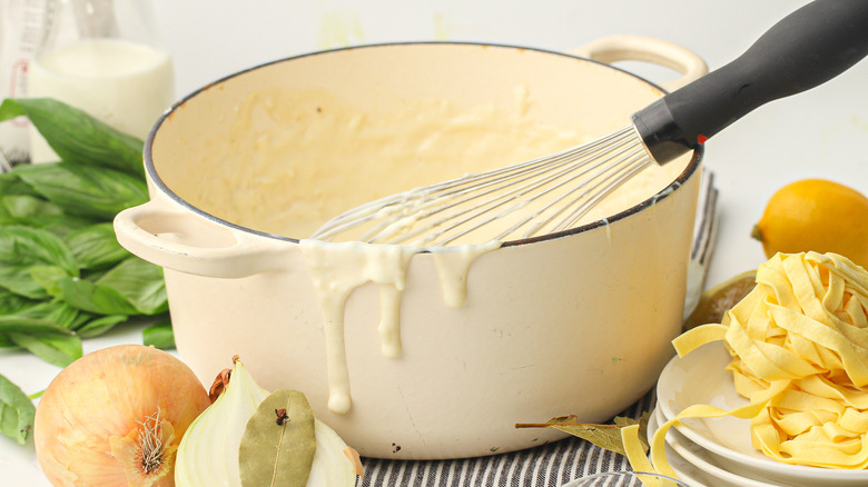Béchamel sauce in bowl with whisk