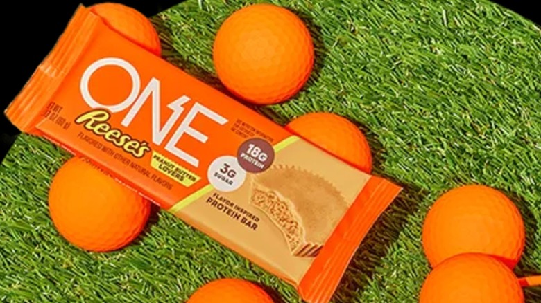 a One bar in orange wrapping on grass with orange balls