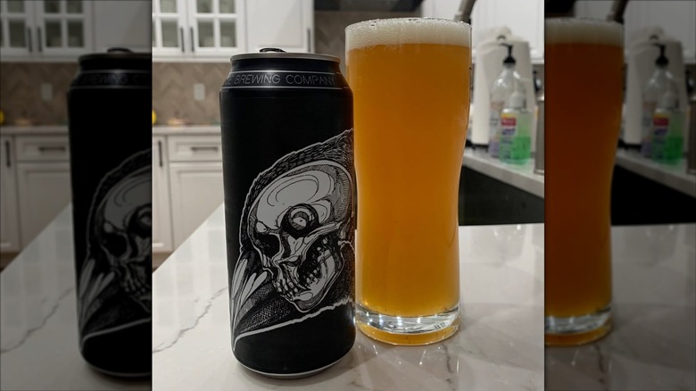 Black can of Within Us IPA next to a filled beer glass.