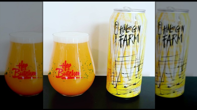 A glass branded with Hop Butcher and a can of Halogen Farm IPA