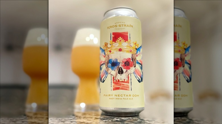 Can of Fairy Nectar in foreground, background of filled glass of beer.