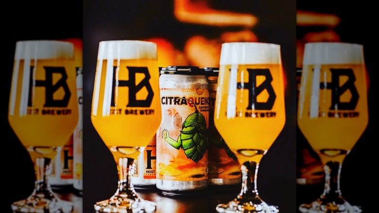 Two filled glasses in the foreground, cans of Citraquench'l in the background.